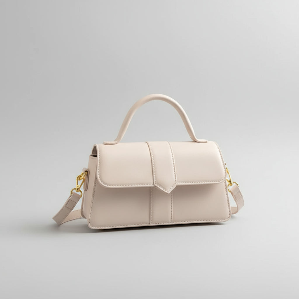 Beige handbag held by a hand with red nail polish on a black surface.