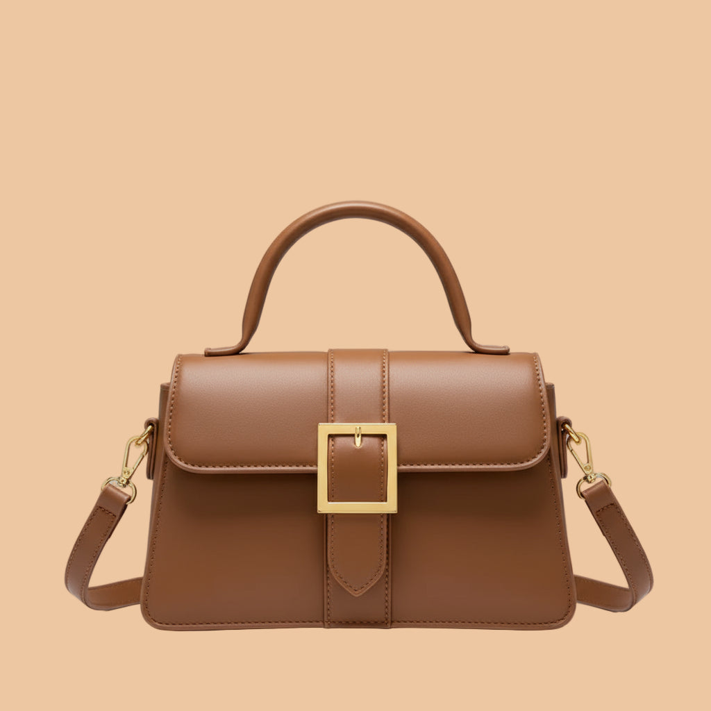 Brown handbag held by a person with a blurred background